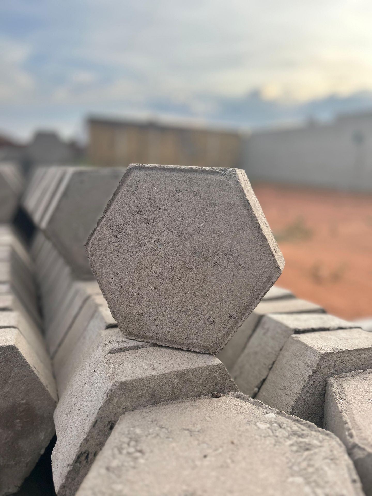 Close-up of a pile of hexagonal concrete blocks stacked outdoors on a blurred background.