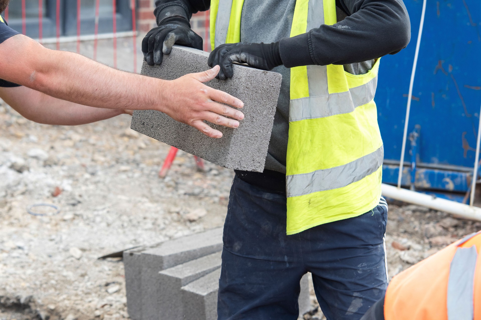 Trabalho em equipe em ação em um canteiro de obras ao colocar blocos para um novo projeto de construção